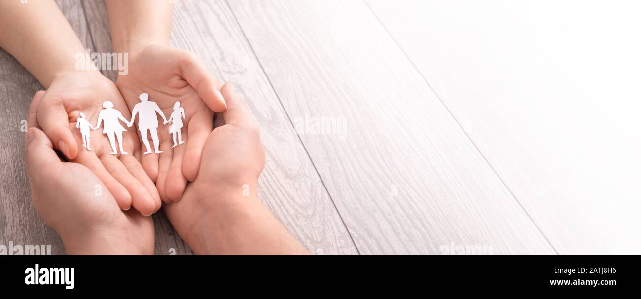 Hände mit ausgeschnittener Papiersilhouette auf dem Tisch. Familienpflegekonzept. Stockfoto