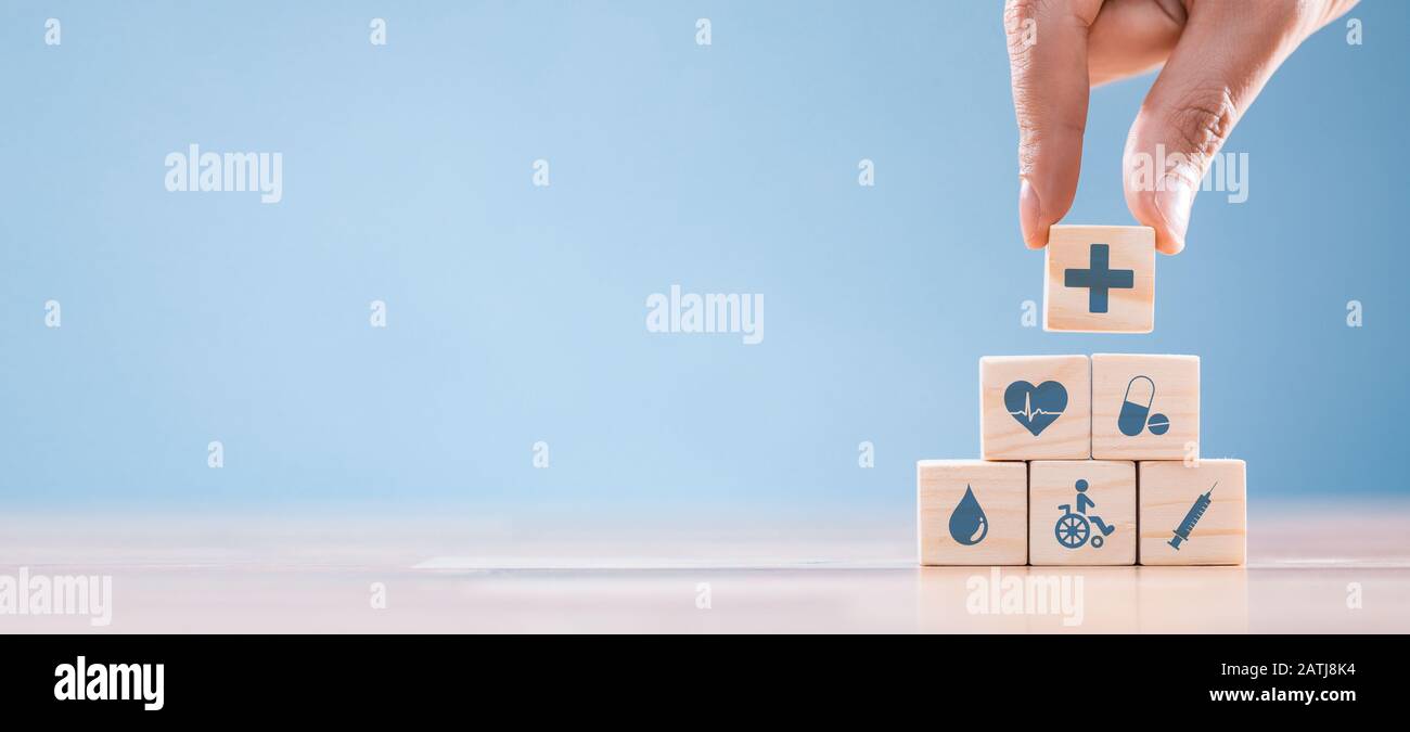 Hand arrangieren Holzblock mit Healthcare Medical Symbol. Krankenversicherung - Konzept. Stockfoto