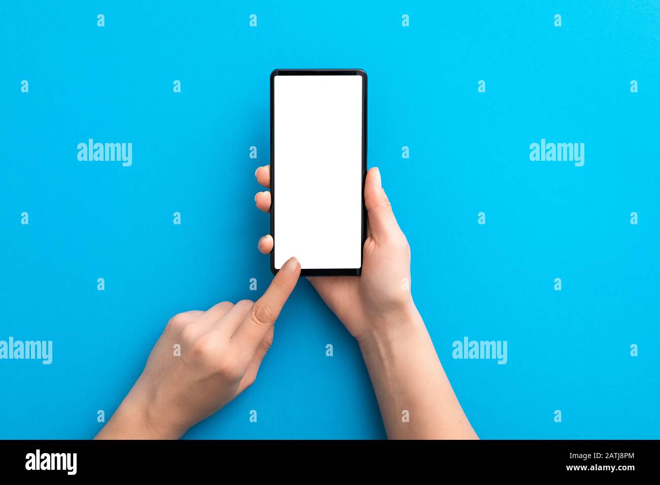 Halten Sie das schwarze Telefon auf blauem Hintergrund und im Beschneidungspfad isoliert. Smartphone-Mock-up-Konzept. Stockfoto