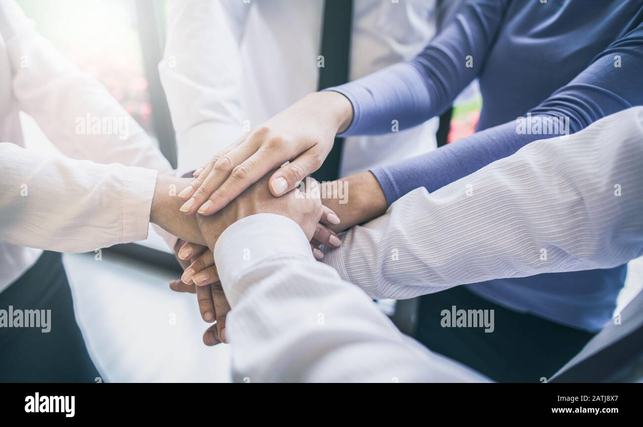 Nahaufnahme der jungen Geschäftsleute, die ihre Hände zusammenlegen. Handstapel. Einigkeit und Teamarbeit. Stockfoto