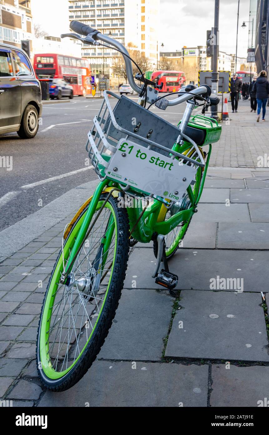 Ein elektronisches Leihfahrrad von Lime-e auf dem Stand auf einem Straßenbelag in London, Großbritannien Stockfoto