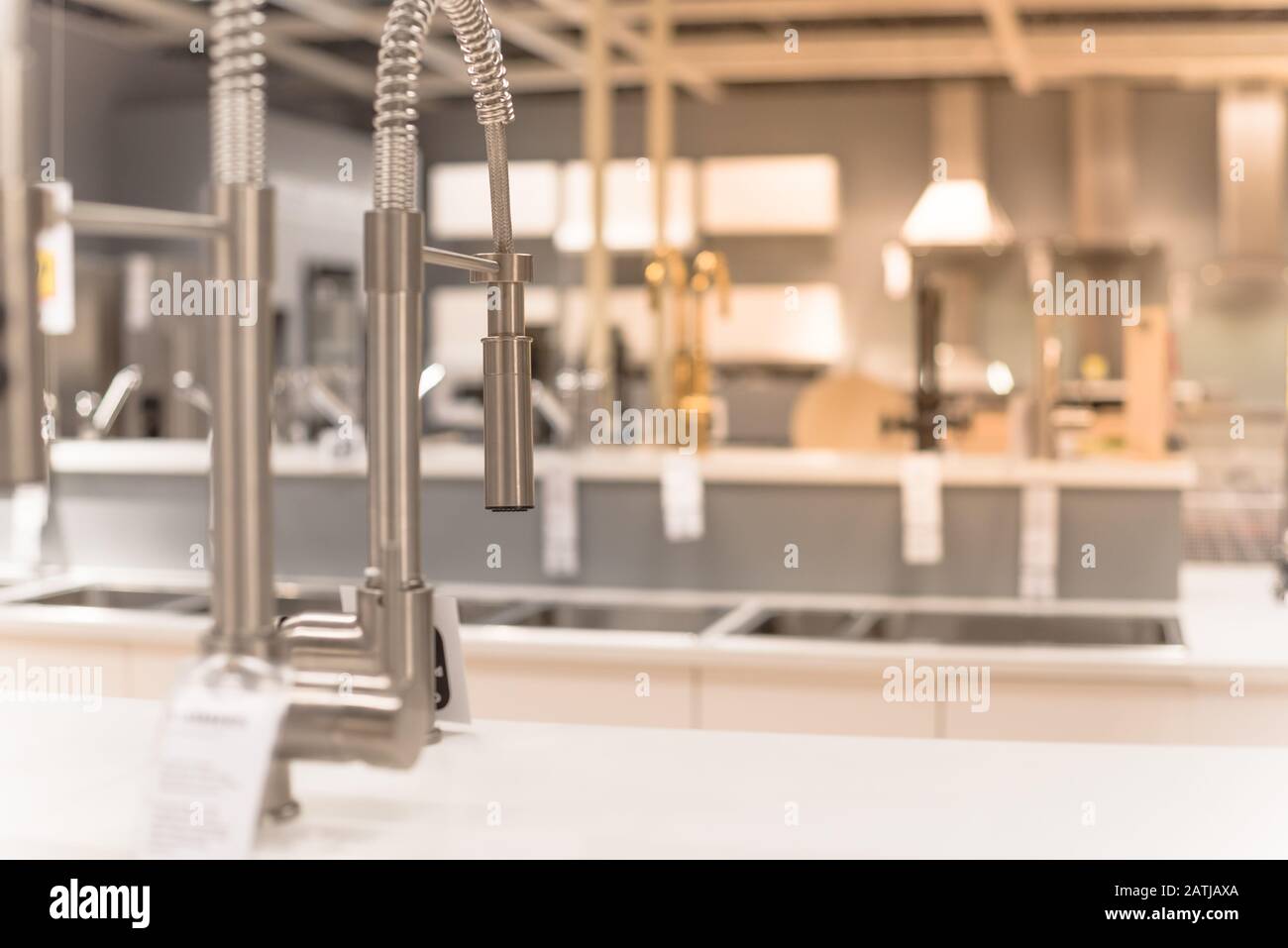 Glänzende Küchenarmaturen mit ausziehendem Spross im Möbel-Showroom in Texas, USA Stockfoto