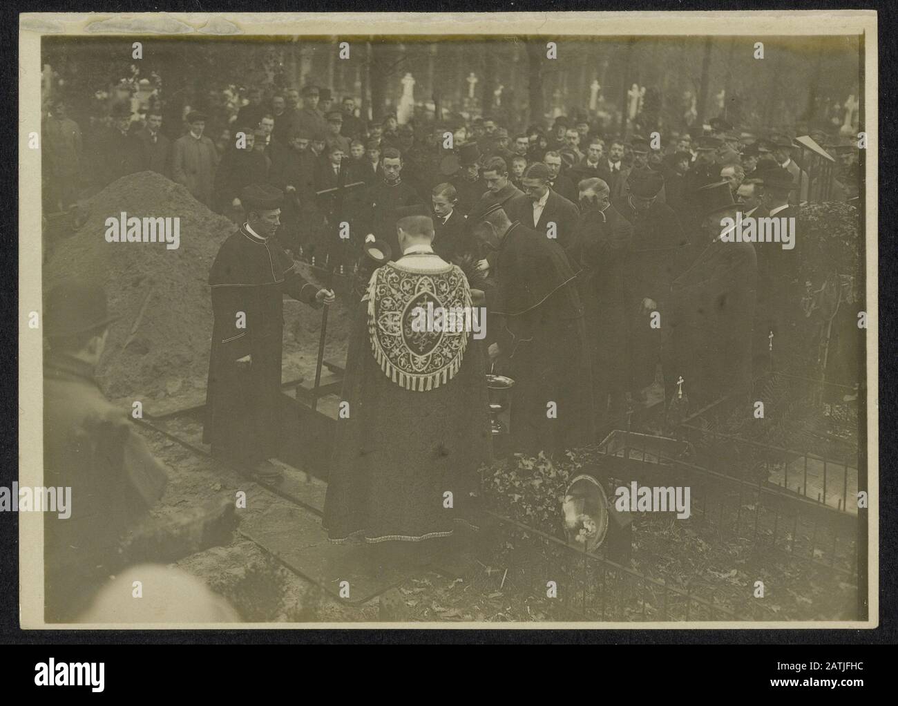 Beschreibung: Große Menschenmenge um ein Grab bei einer Beerdigung unter der Leitung eines Römisch-katholischen Priesters. Datum: {1914-1918} Stichwörter: Beerdigungen, erster Weltkrieg, Geistliche Stockfoto