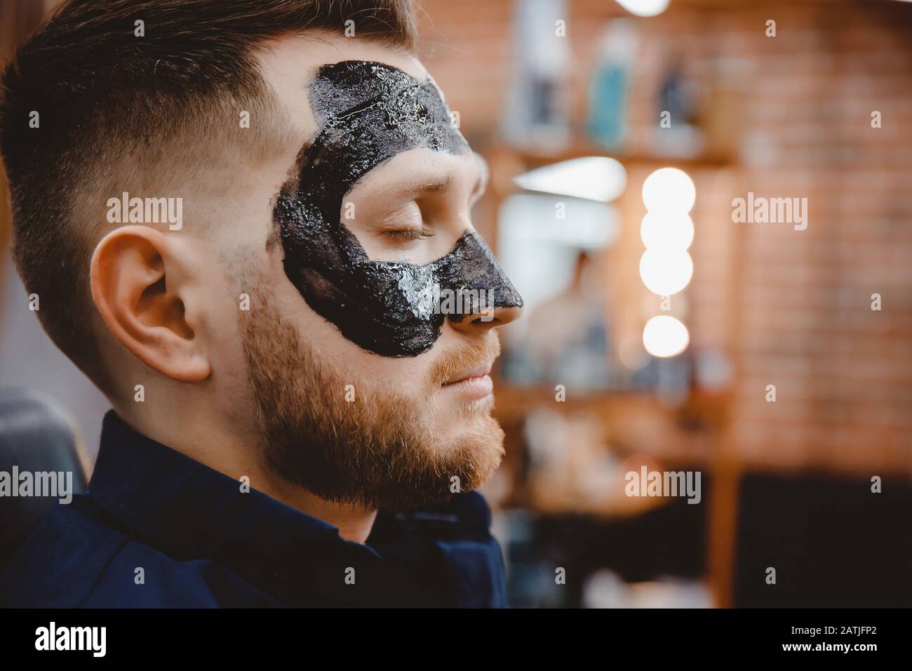 Gutaussehender Mann mit schwarzer Anthrazit Gesichtsmaske, Konzept  Hautpflege, Porenreinigung von Akne Stockfotografie - Alamy