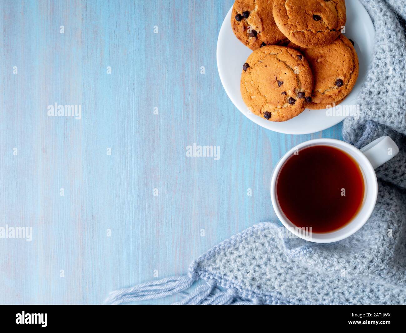 Schokoladen-Chip-Plätzchen mit Kakao, Marshmallow. Gemütlicher Abend, Tasse Tee, Kopierraum. Tisch aus grauem Stein Stockfoto