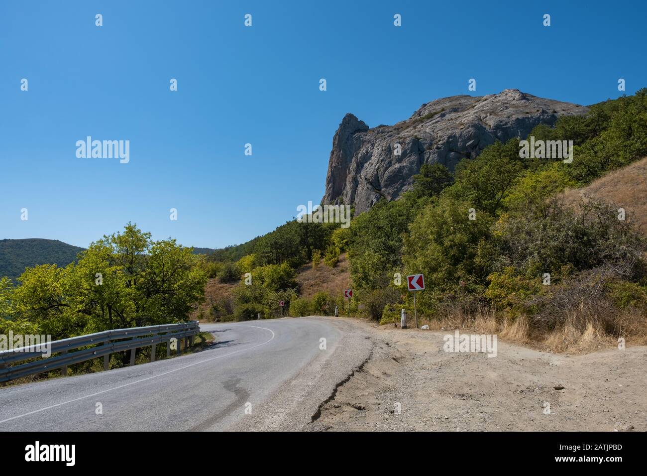 Eine kurvenreiche Asphaltstraße an der Schwarzmeerküste der Krim an einem sonnigen Sommertag. Stockfoto