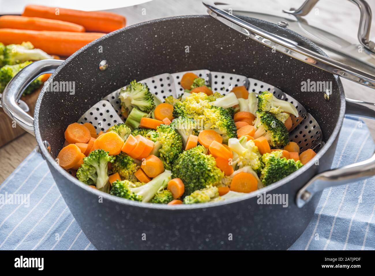 Gedämpftes gemischtes Gemüse in schwarzem Topf. Gesundes Gemüsekonzept Stockfoto
