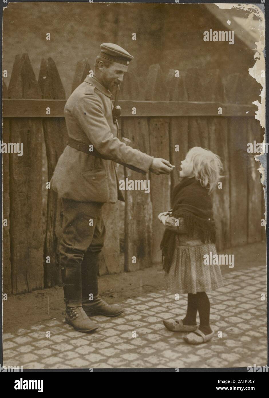 Beschreibung: Deutscher Soldat gibt einem Kind einen Imbiss Datum: {1914-1918} Schlüsselwörter: WWI, Kinder, Offiziere, Soldaten, Imbisse Stockfoto