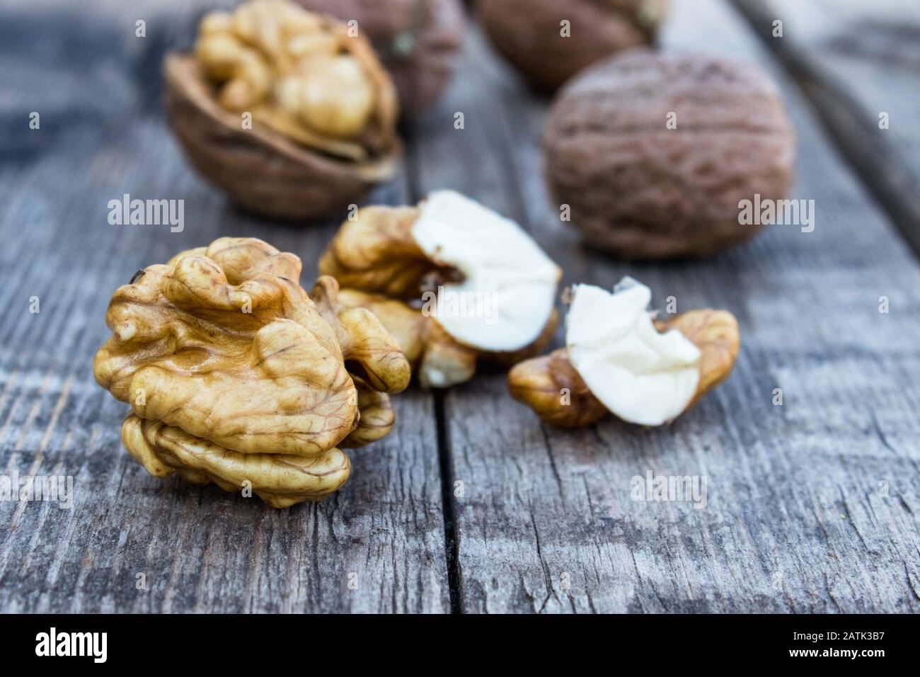 Geschälte Walnüsse und Nusskernel liegen auf einem rustikalen alten Holztisch. Walnüsse ernten. Stockfoto