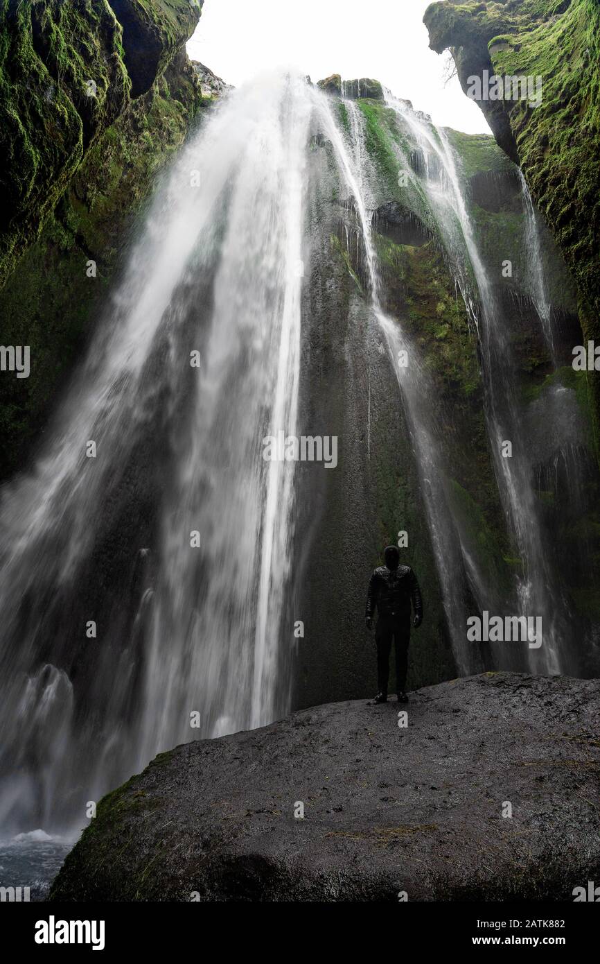 Mann, der in der malerischen Höhle des Gljufrafoss Wasserfalls in Island steht Stockfoto