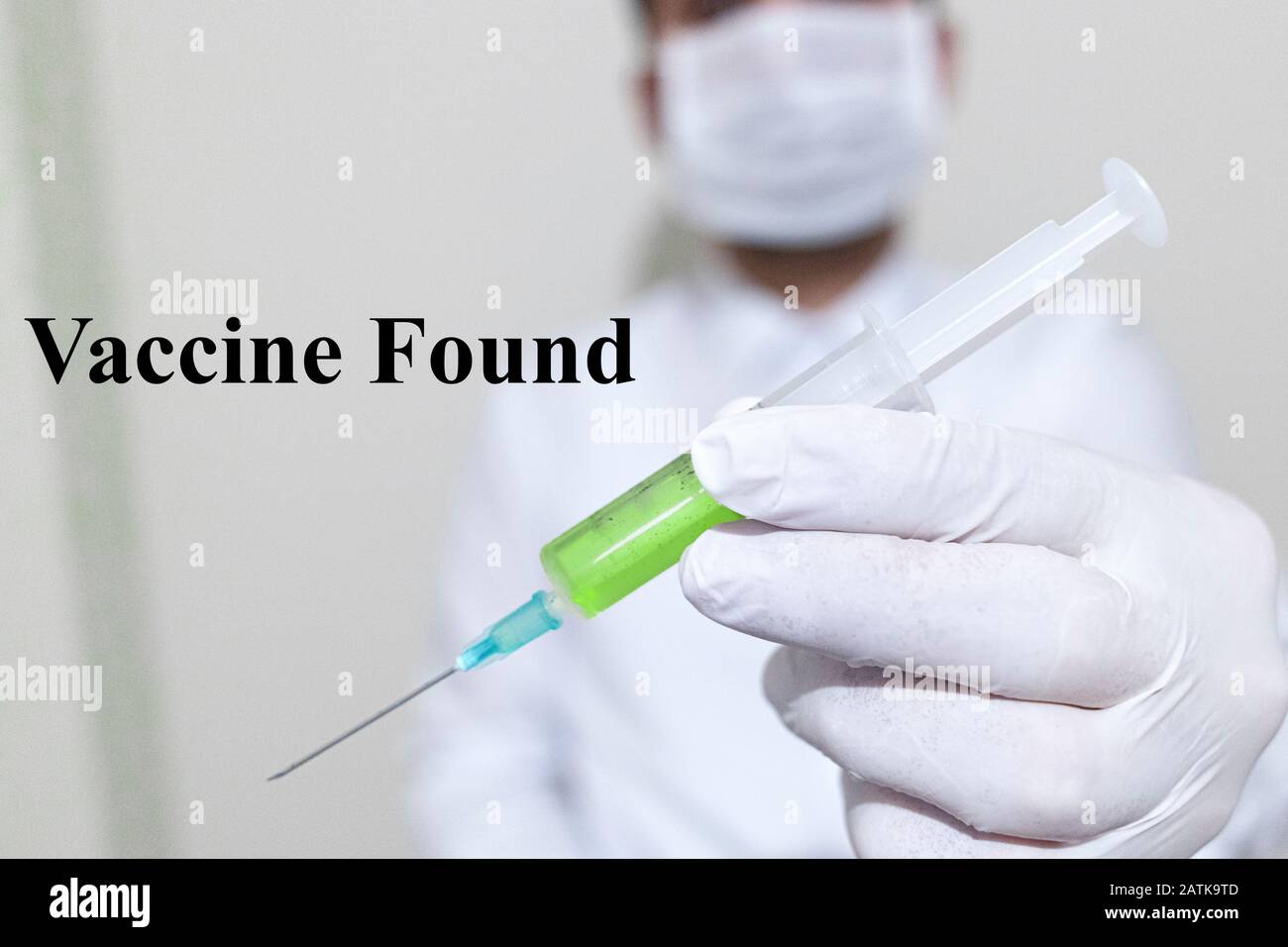 Er hält einen Coronavirus Impfstoff. Der Impfstoff ist grün. Auf der linken Seite steht der gefundene Impfstoff. Stockfoto