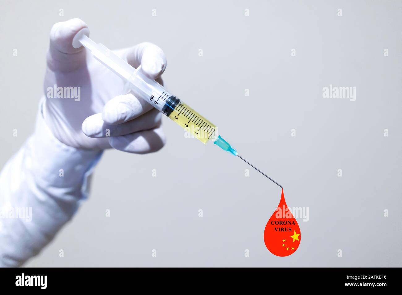 Eine Hand mit Handschuhen in weißer Farbe. Der Impfstoff wird in der Hand gehalten. Fällt auf der Nadelspitze rot ab. Chinesische Flagge. Stockfoto