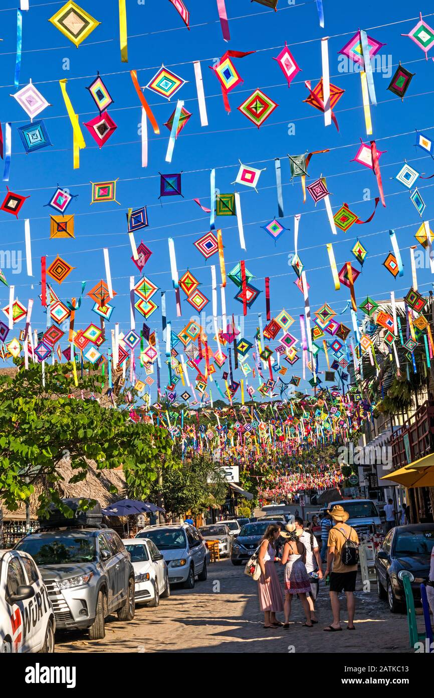 Mexiko, Nayarit, San Blas, eine Straßenszene, die mit Ojos de Dios und Touristen dekoriert ist Stockfoto