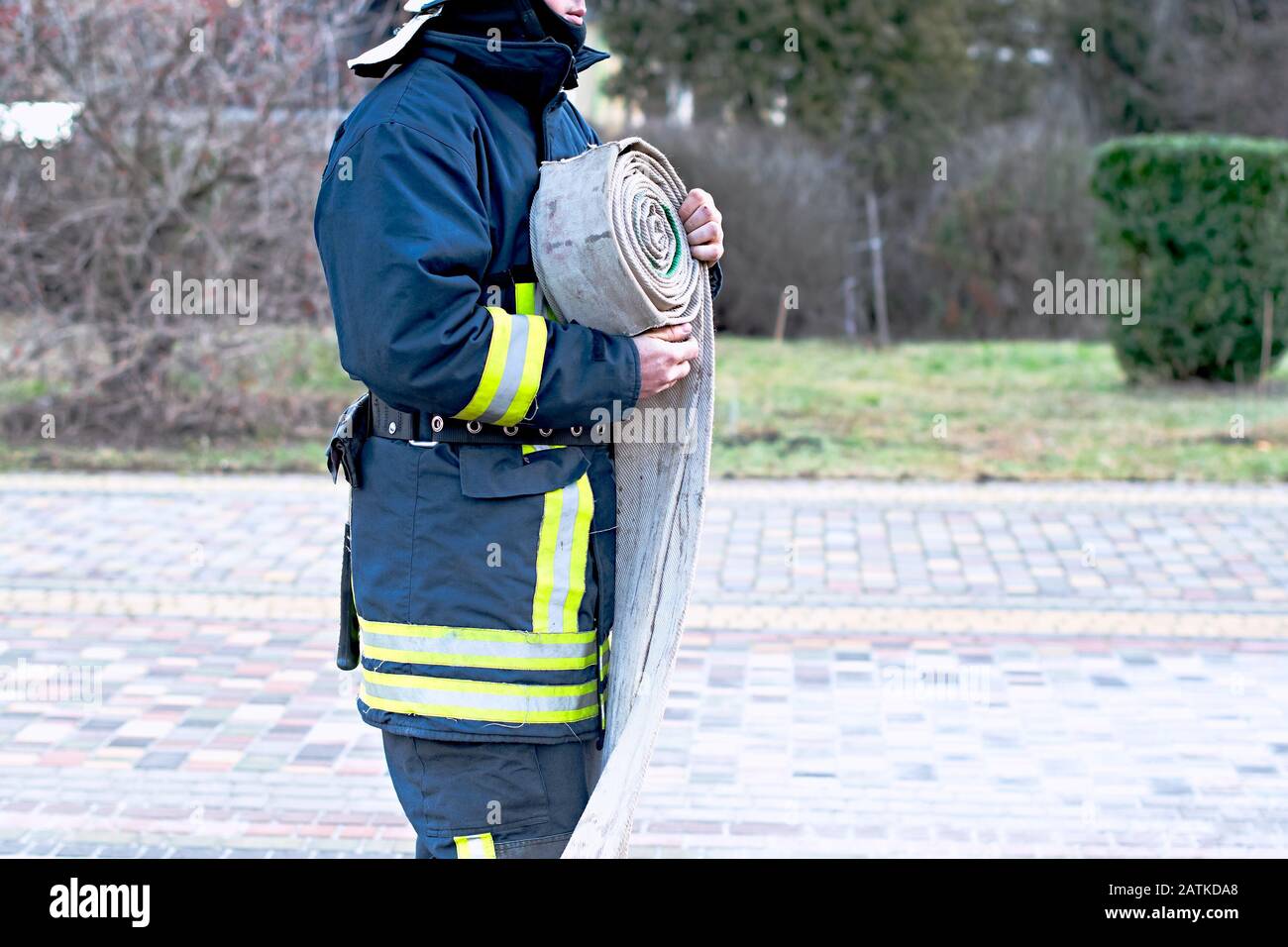 Feuerwehrmann verdreht Feuerwehrschlauch nach dem Brand Stockfoto