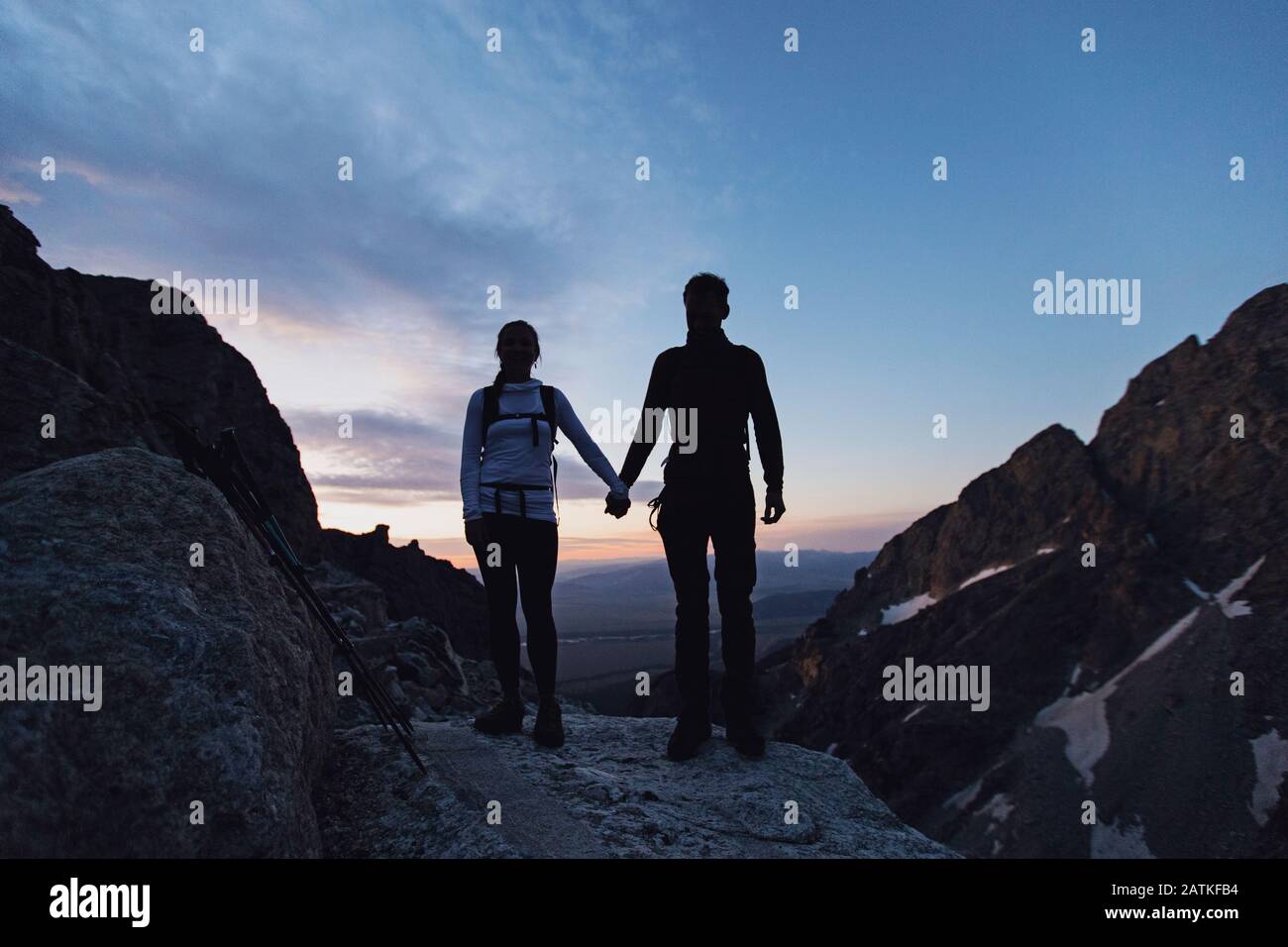 Das Paar hält sich beim Wandern bei Sonnenaufgang in den Bergen die Hände Stockfoto