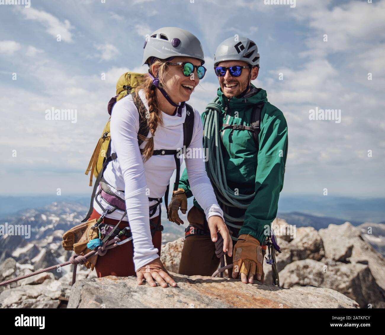 Das Paar lächelt mit Freude, nachdem es den Gipfel des Grand Teton, Wyoming, erreicht hat Stockfoto