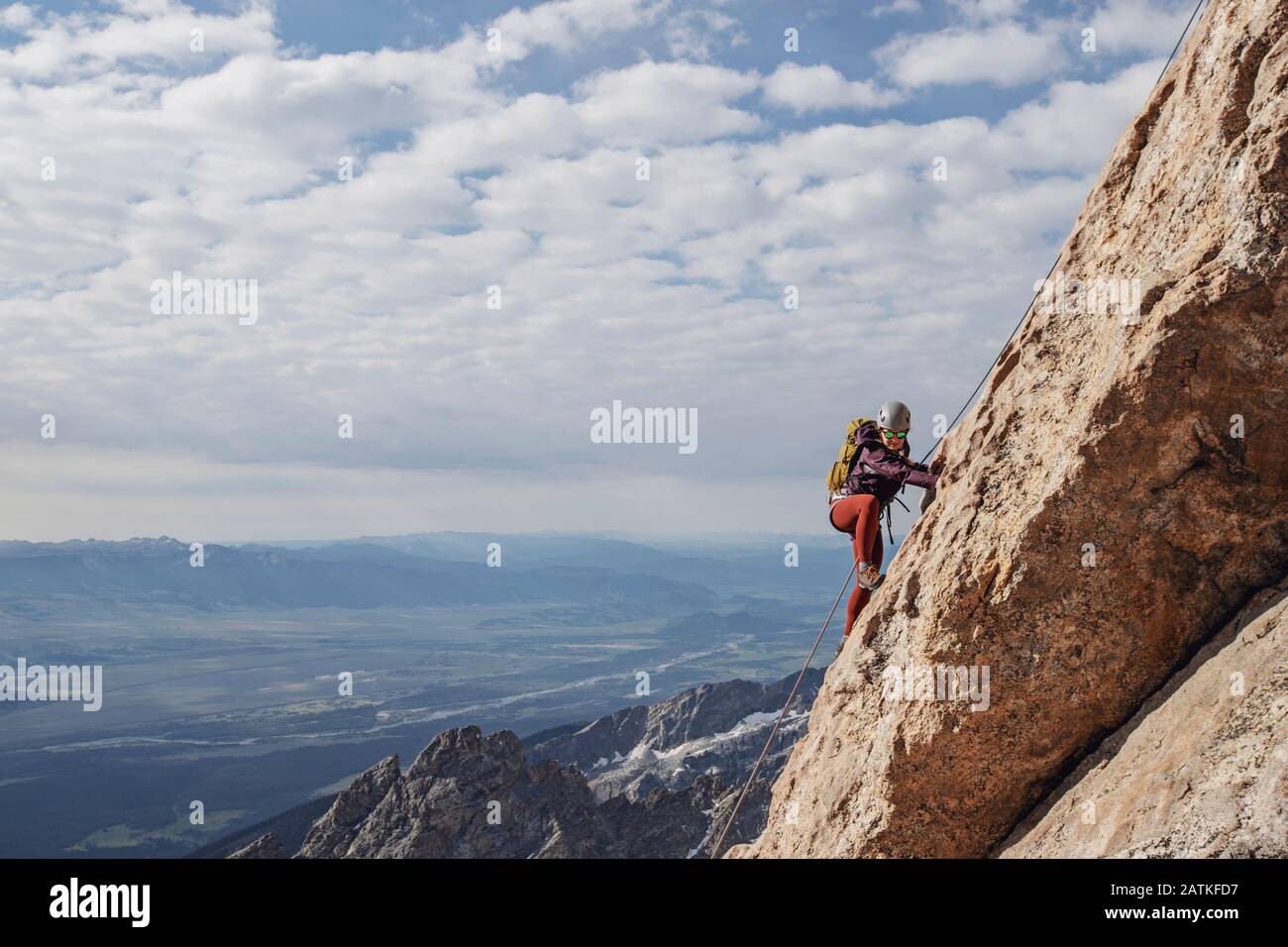 Eine gesprenkelte Kletterin bestiegen eine Klippe in den Tetons, Wyoming Stockfoto