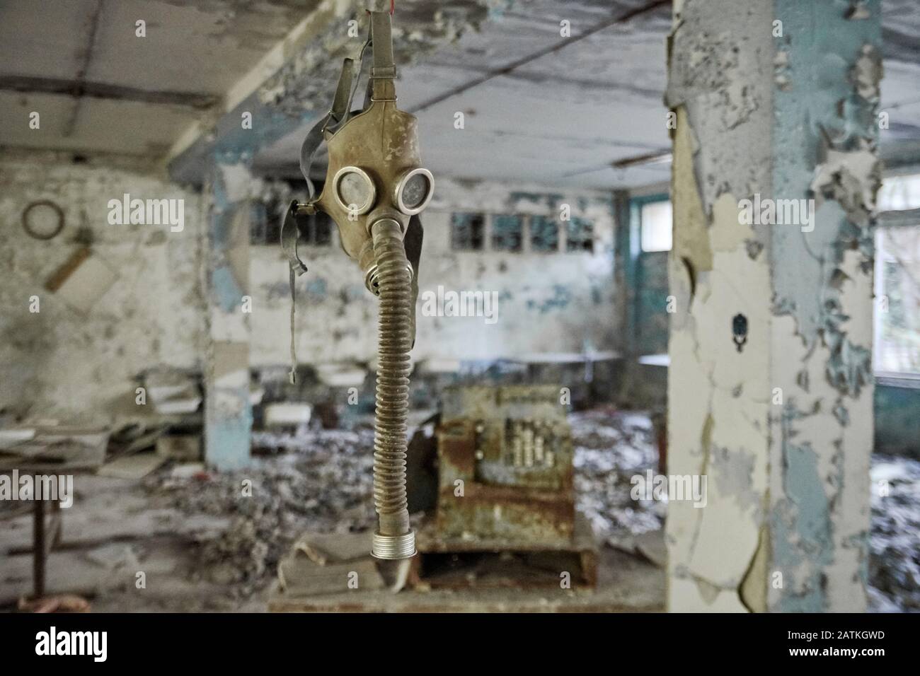 Gasmasken auf dem Boden mit einem alten Fernseher in einer verlassenen Mittelschule in Pripyat - Atomkraftwerkzone von Tschernobyl der Entfremdung Stockfoto