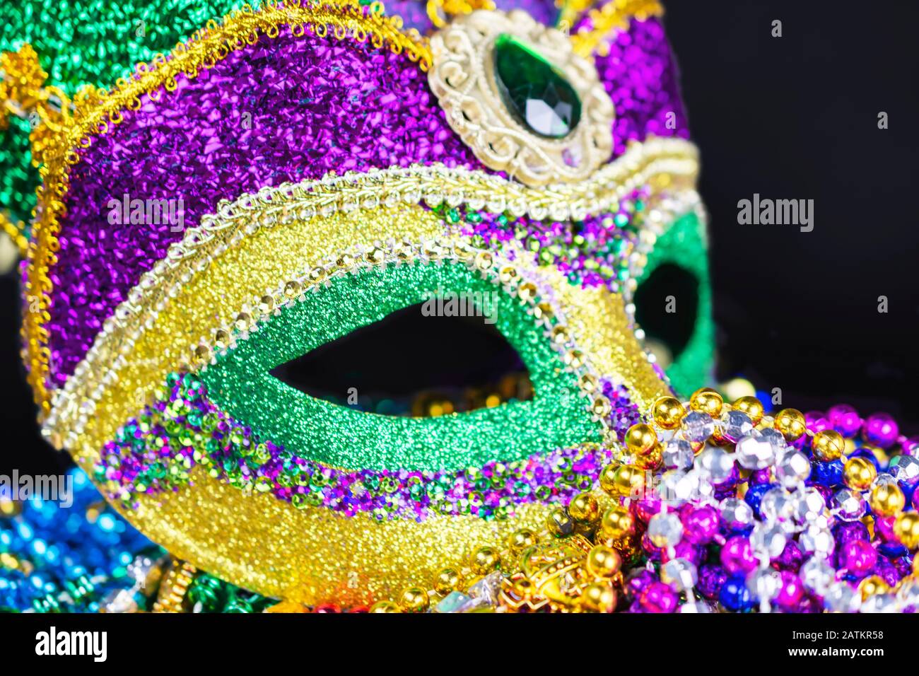 Nahansicht einer Festivalmaske von der Vorderseite aus. Auf ein Bett mit Perlen gelegt. Stockfoto