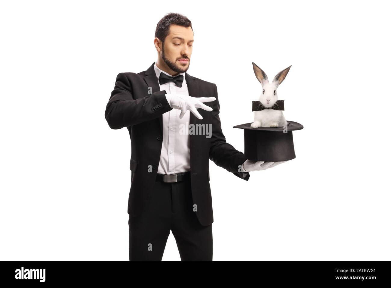 Junger männlicher Zauberer, der einen Zaubertrick mit einem Kaninchen in einem auf weißem Hintergrund isolierten Hut macht Stockfoto
