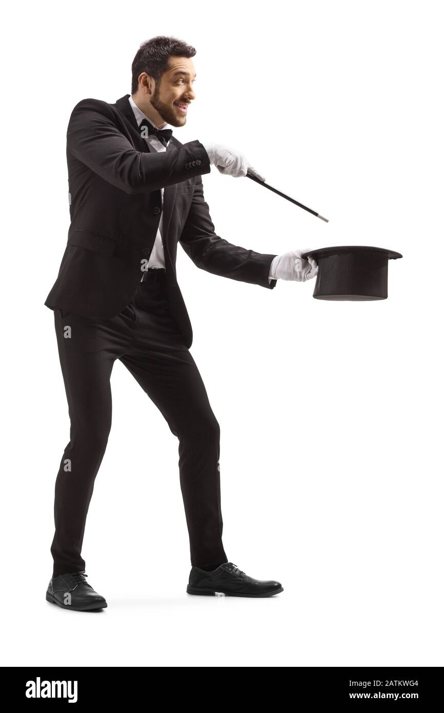 Lange Aufnahme eines Zauberers, der einen Zaubertrick mit einem Zauberstab und einem auf weißem Hintergrund isolierten Tophat macht Stockfoto