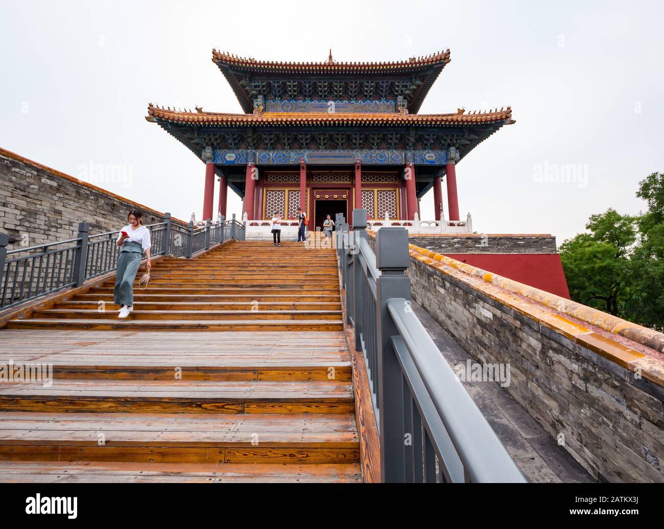 Asiatische Frau, die auf ein Handy blickt, das die Stufen hinunter geht, East Prosperity Gate, Inner Court, Forbidden City, Peking, China Stockfoto