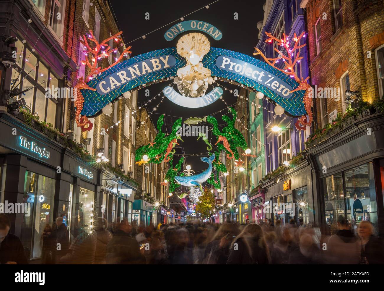 Carnaby Street Weihnachtsbeleuchtung in der Nacht mit der Bewegung der Leute, die unten einkaufen. Foto mit langer Belichtung. Stockfoto