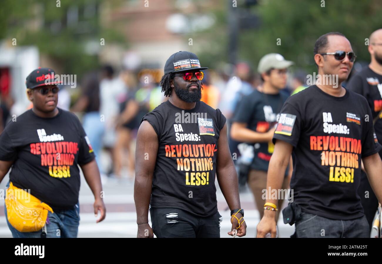 Chicago, Illinois, USA - 8. August 2019: Die Bud Billiken Parade, Menschen, die Zeichen tragen und Hemden tragen, die die soziale Revolution fördern Stockfoto