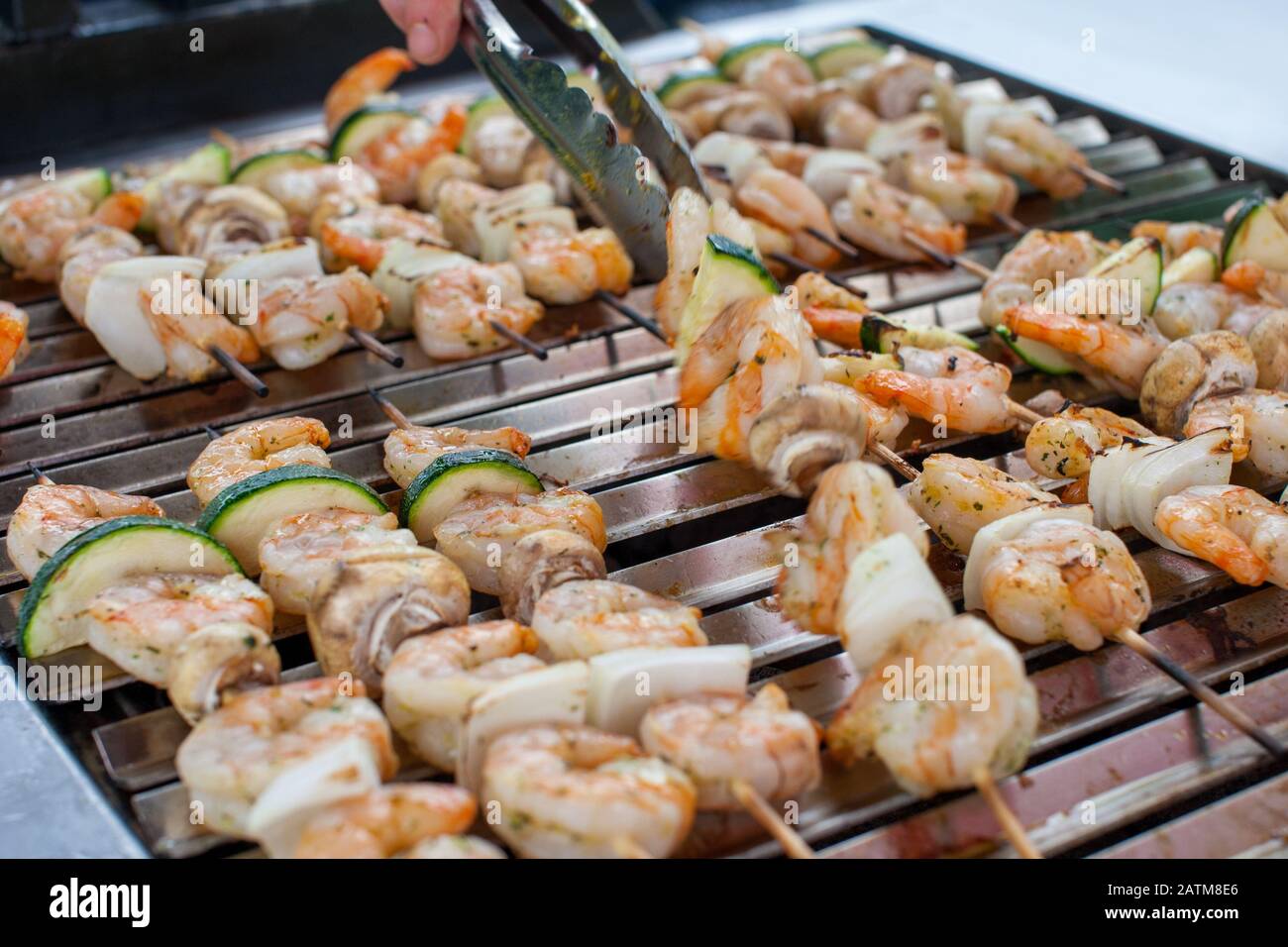 Picknick-Szene im Freien mit Fisch und Meeresfrüchten bbq mit köstlichen Garnelen auf Skews und Garnelen auf einem Grill Stockfoto