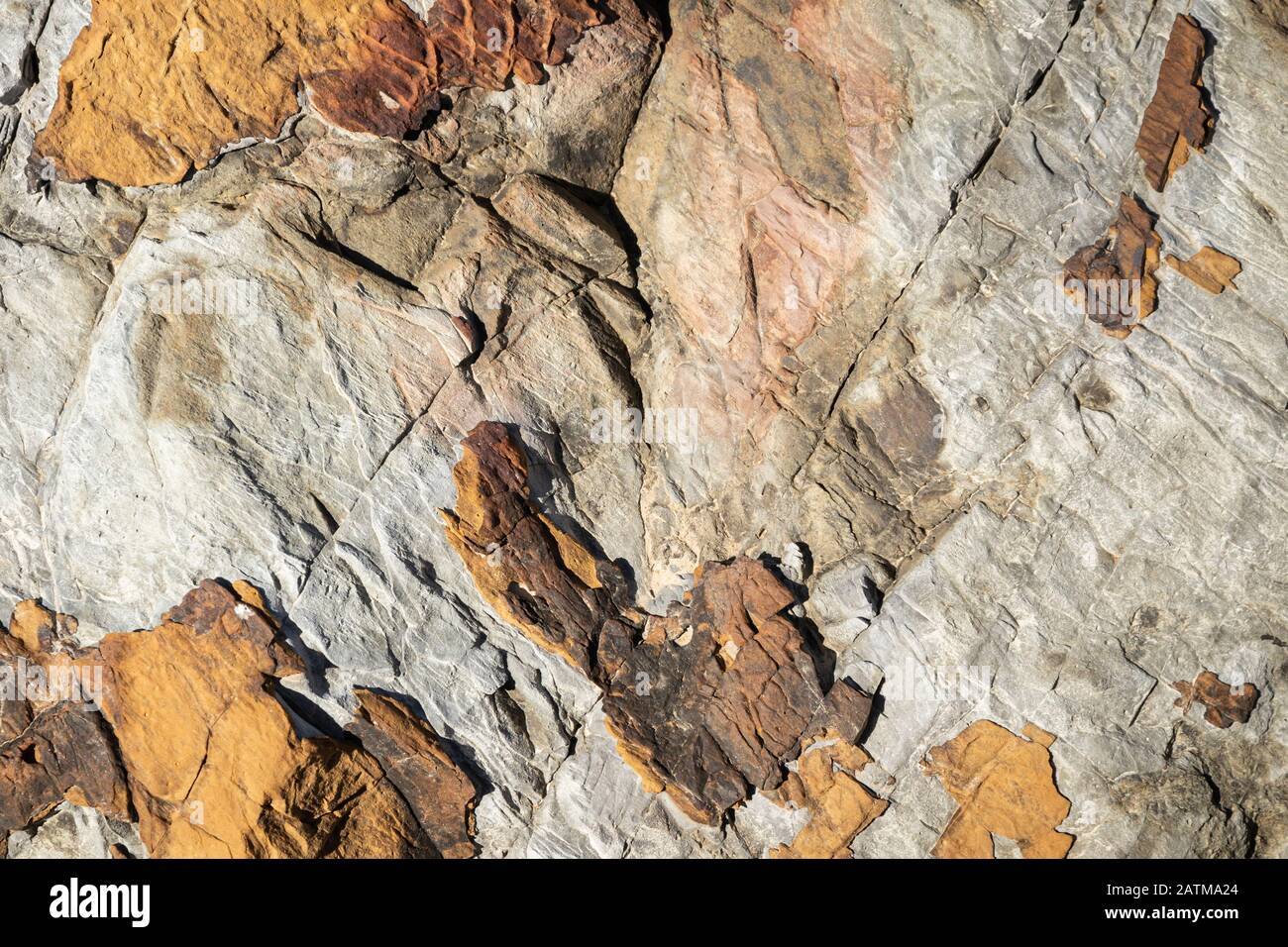 Nahaufnahme der Struktur der braunen Steinfelsen mit schwarzen Rissen im gesamten Texturhintergrund Stockfoto