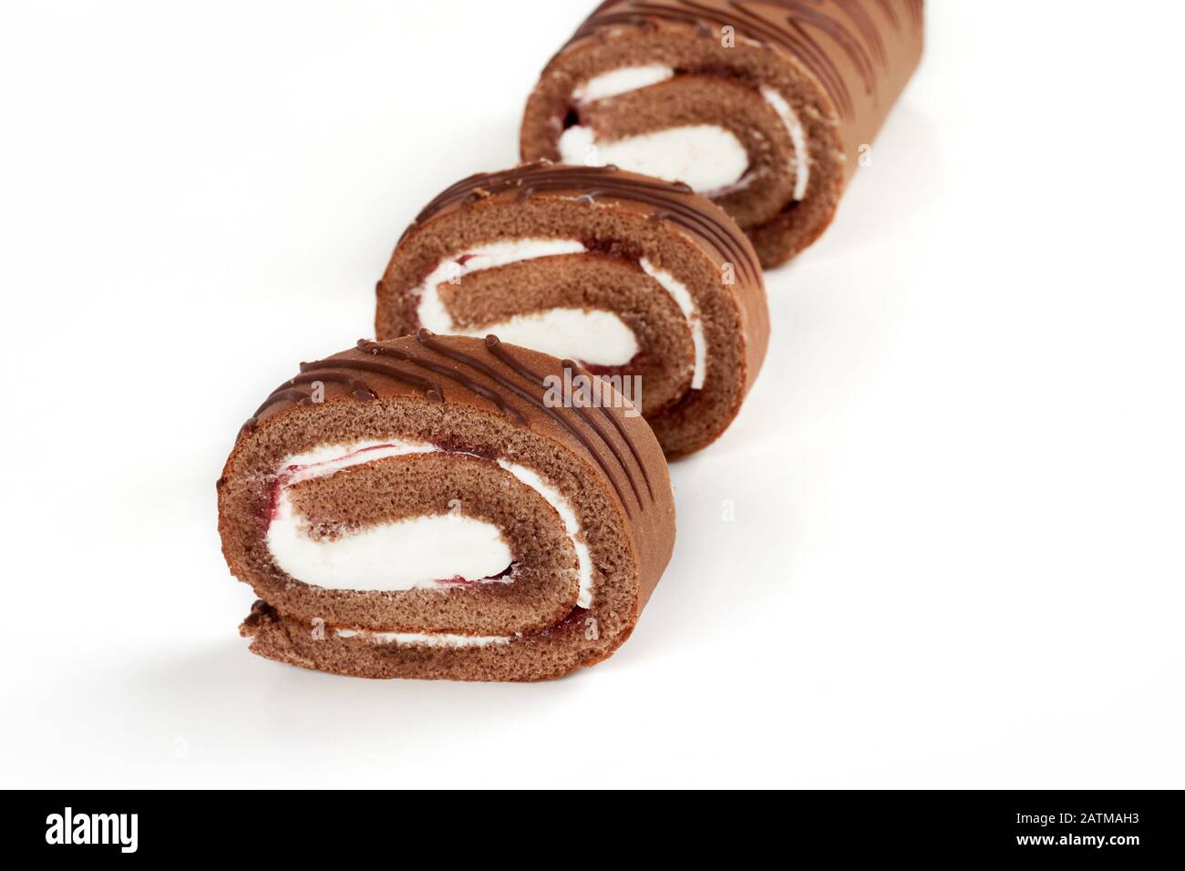In Scheiben geschnittener Schokoladenkuchen-Rollkuchen isoliert auf weißem Hintergrund. Stockfoto
