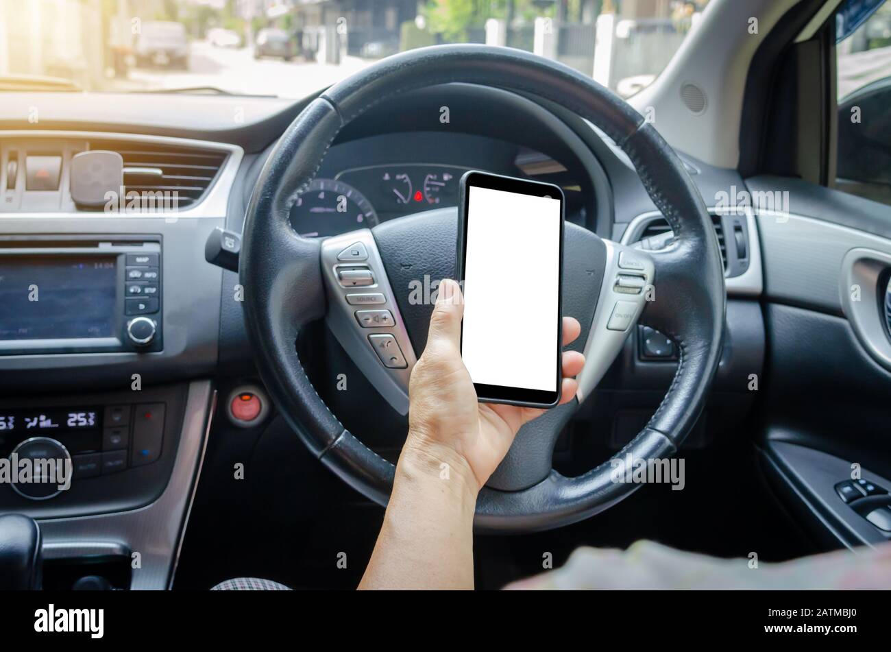 Die Hand der Frauen hält ein Handy im Auto.Clipping Path Stockfoto