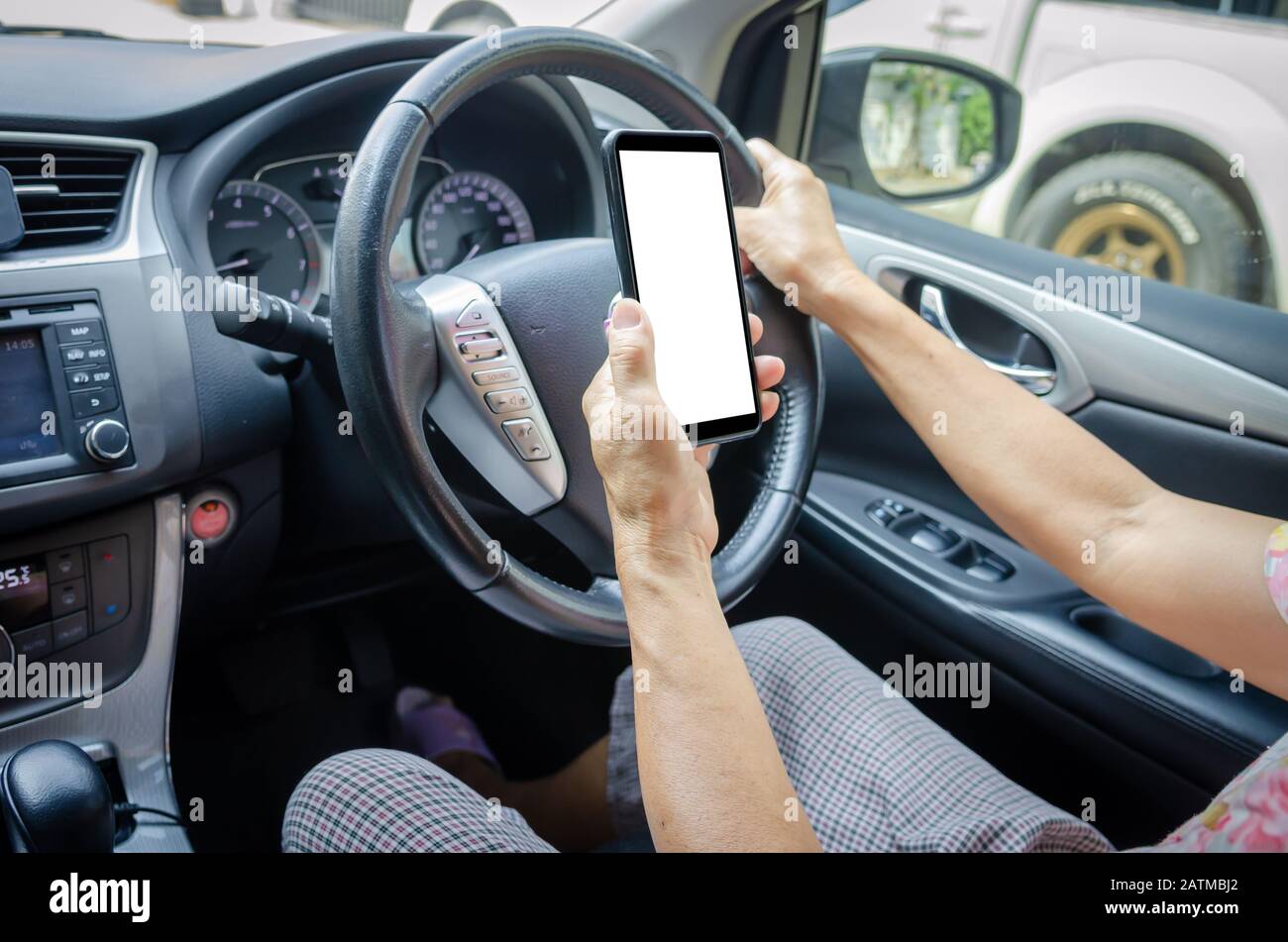 Die Hand der Frauen hält ein Handy im Auto.Clipping Path Stockfoto