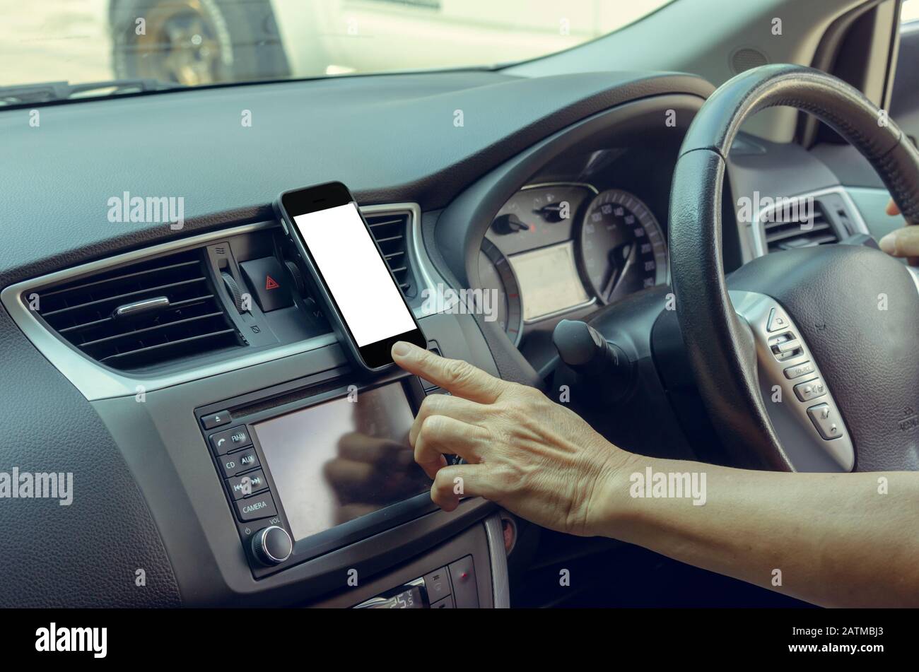 Die Hand der Frauen hält ein Handy im Auto.Clipping Path Stockfoto