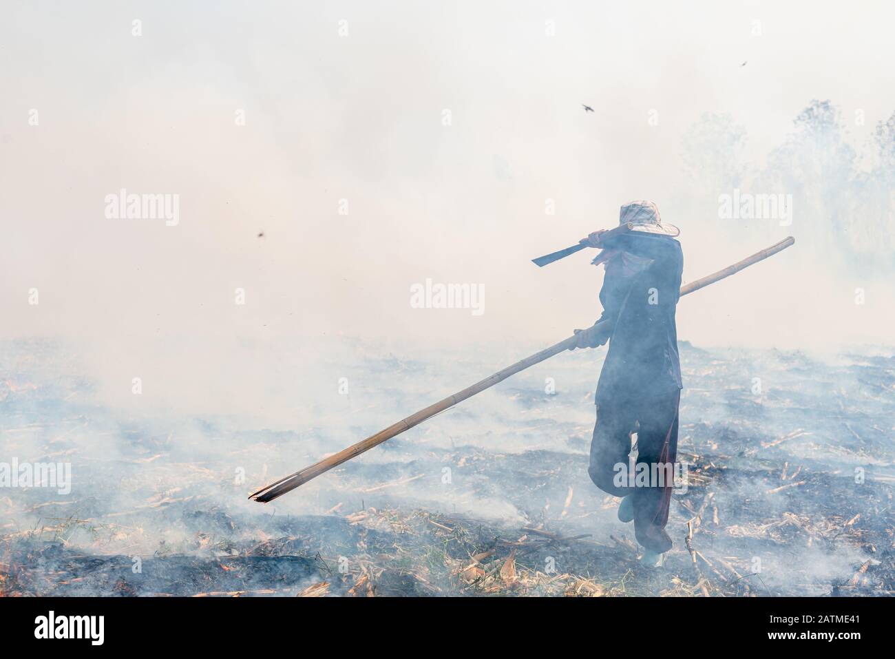 Bauern, die Thailand beleuchten, kontrollierten das Verbrennen des Präriefeldes. Stockfoto