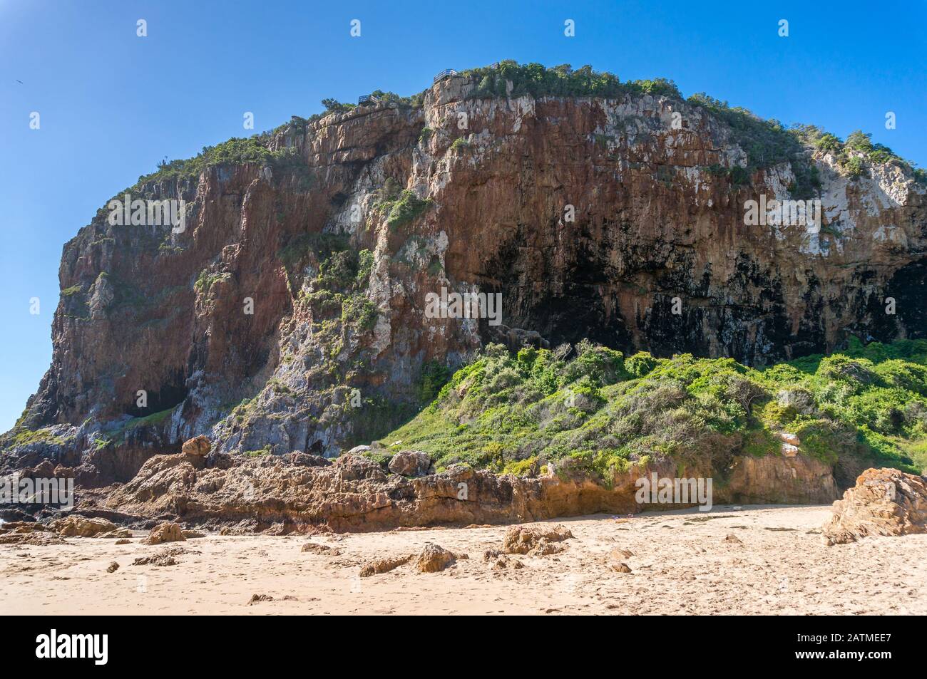 Riesiger Felsberg, Klippe auf dem Sand. Knysna in Südafrika. Die Geologie rockt den natürlichen Hintergrund Stockfoto