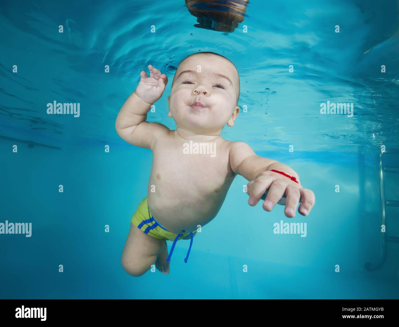 Junge lernt, unter Wasser in einem Schwimmbad zu tauchen Stockfoto