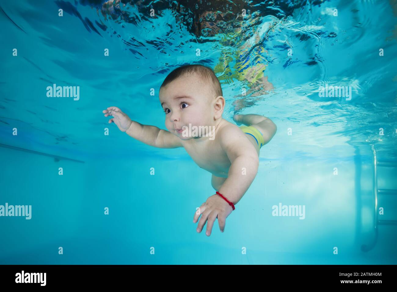 Junge lernt, unter Wasser in einem Schwimmbad zu tauchen Stockfoto