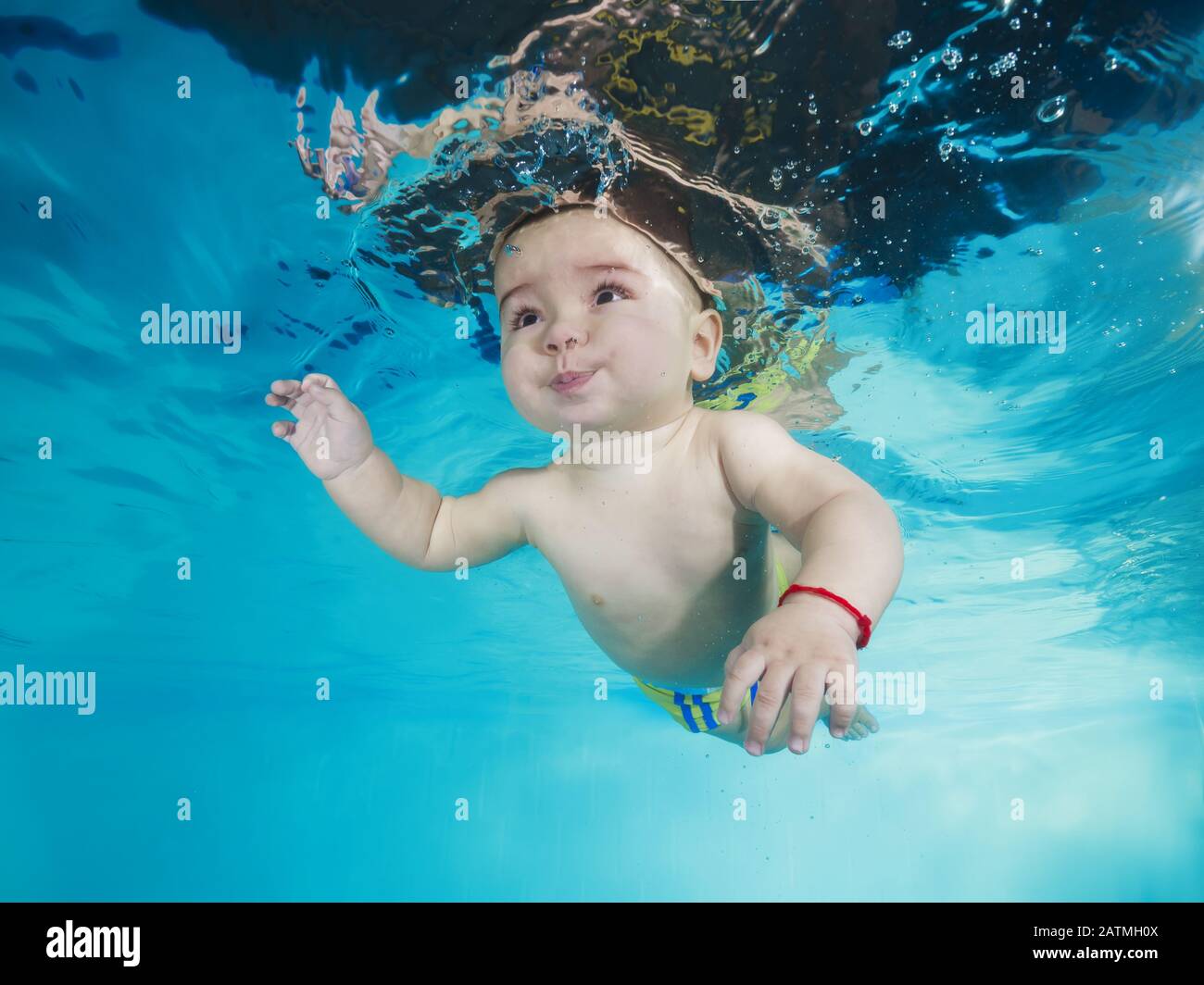 Junge lernt, unter Wasser in einem Schwimmbad zu tauchen Stockfoto