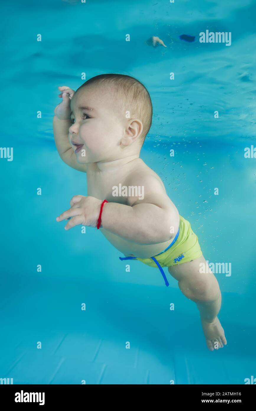 Junge lernt, unter Wasser in einem Schwimmbad zu tauchen Stockfoto