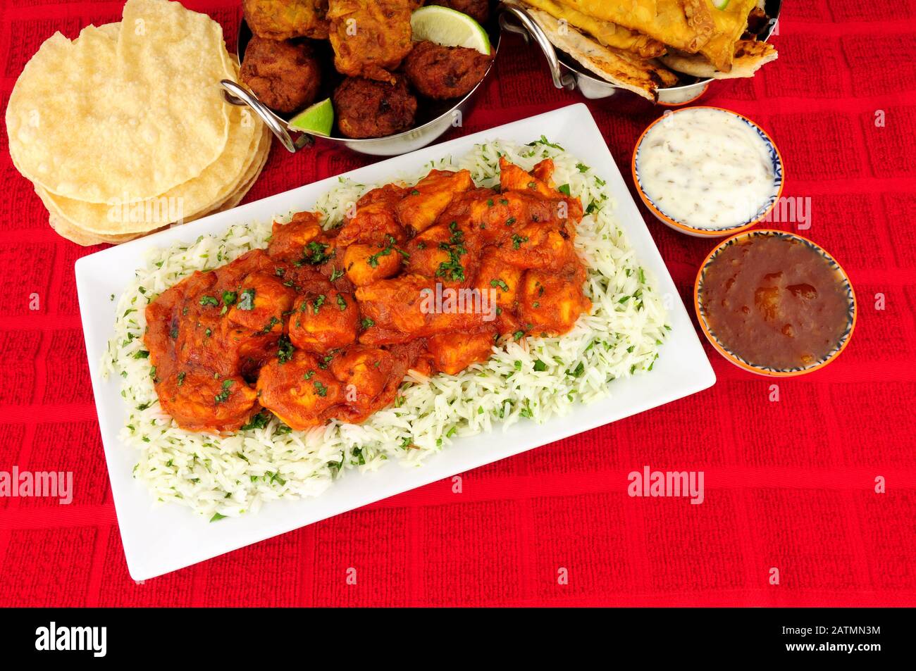 Hühnercurry-Mahlzeit mit Reis und einer Auswahl an Seiten und Dips Stockfoto