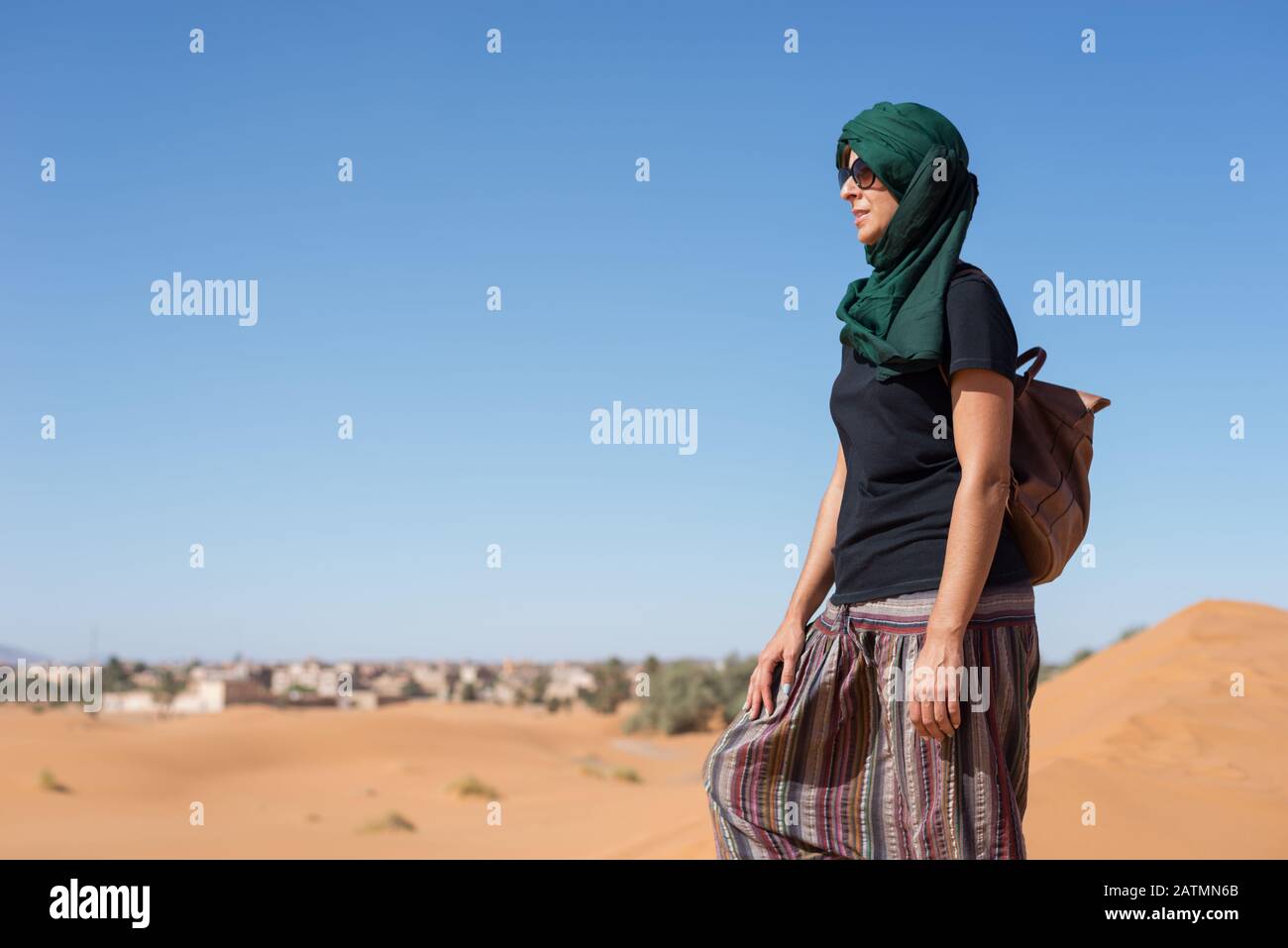 Frau, die die Horizontdünen in der marokkanischen Sahara-Wüste betrachtet. Stockfoto