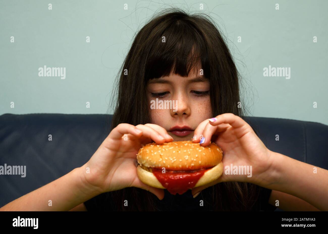 6-jähriges Mädchen, das einen Hühnerburger isst Stockfoto