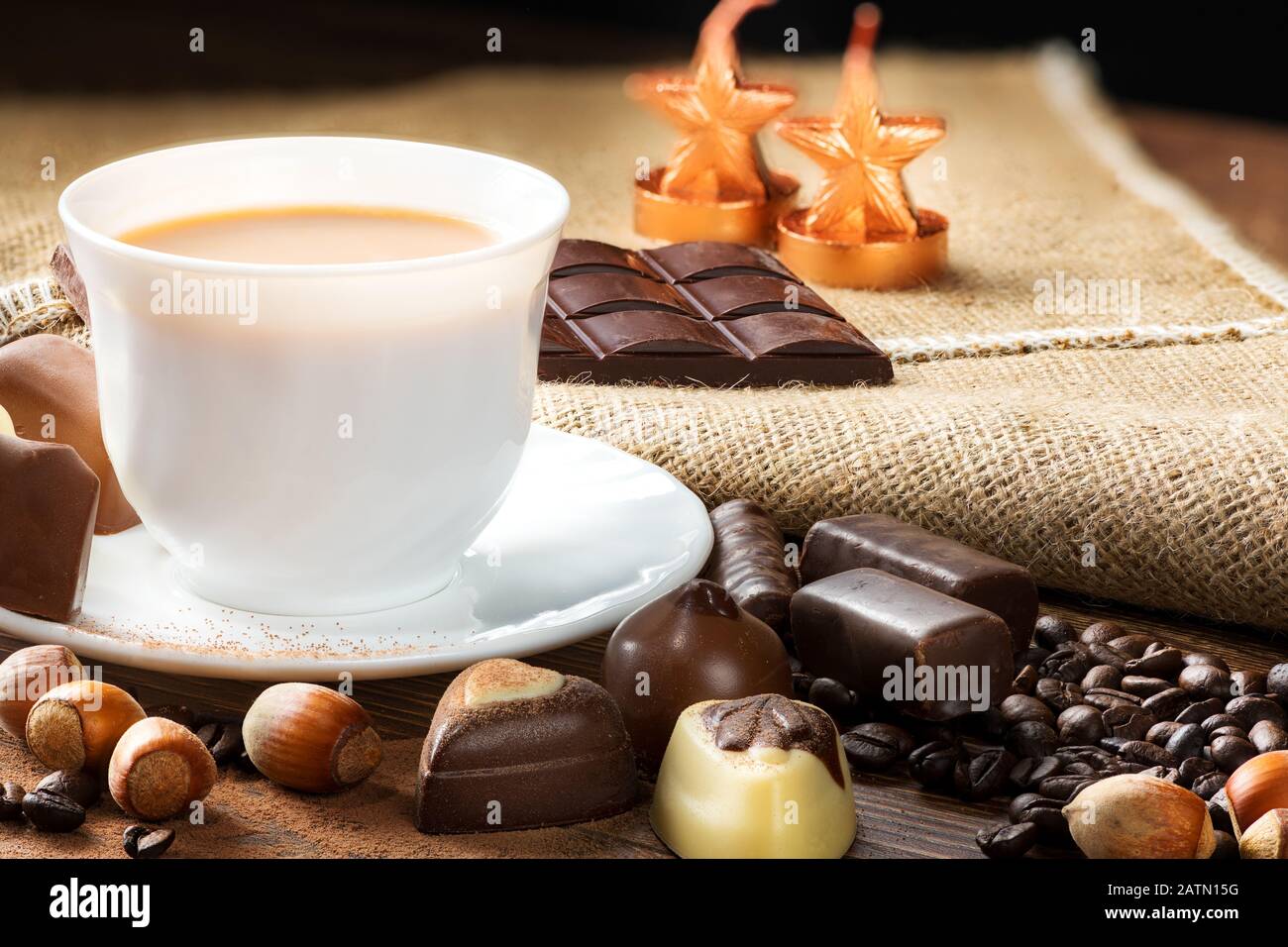 Tasse köstlichen Latte mit Schokolade und gerösteten Kaffeebohnen in Burlap Stockfoto