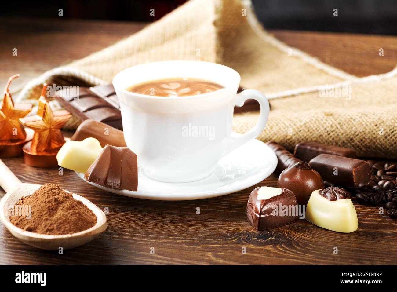 Tasse köstlichen Latte mit Schokolade und gerösteten Kaffeebohnen in Burlap Stockfoto