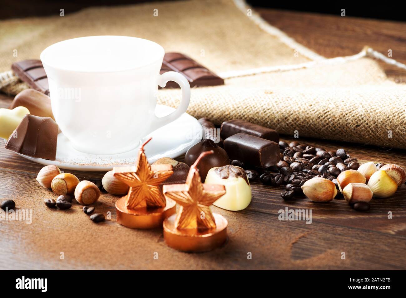 Tasse köstlichen Latte mit Schokolade und gerösteten Kaffeebohnen in Burlap Stockfoto