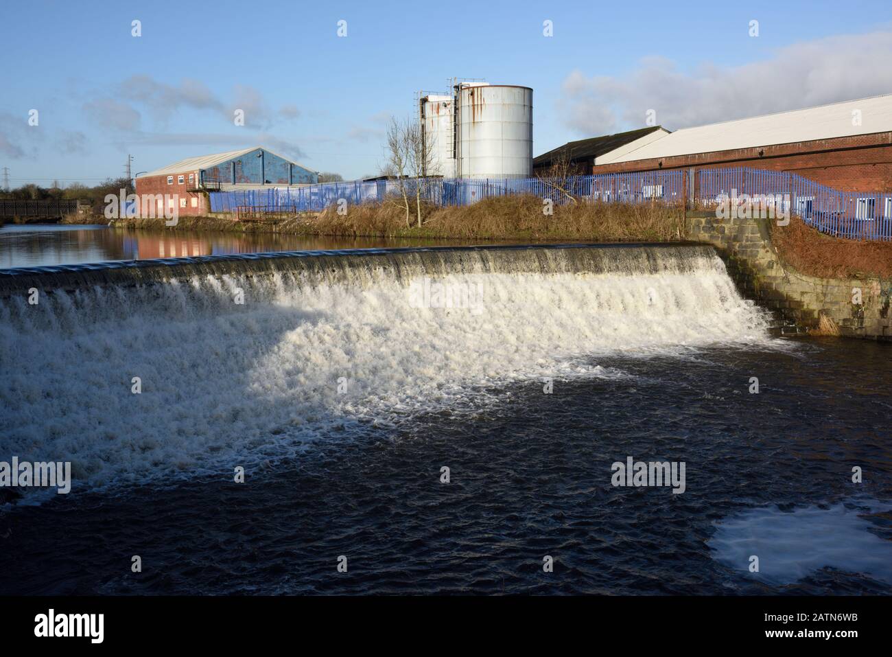 Wehr an der irwell mit Industriegebäuden und Silos in Der Hintergrund in radcliffe in Bury lancashire uk Stockfoto