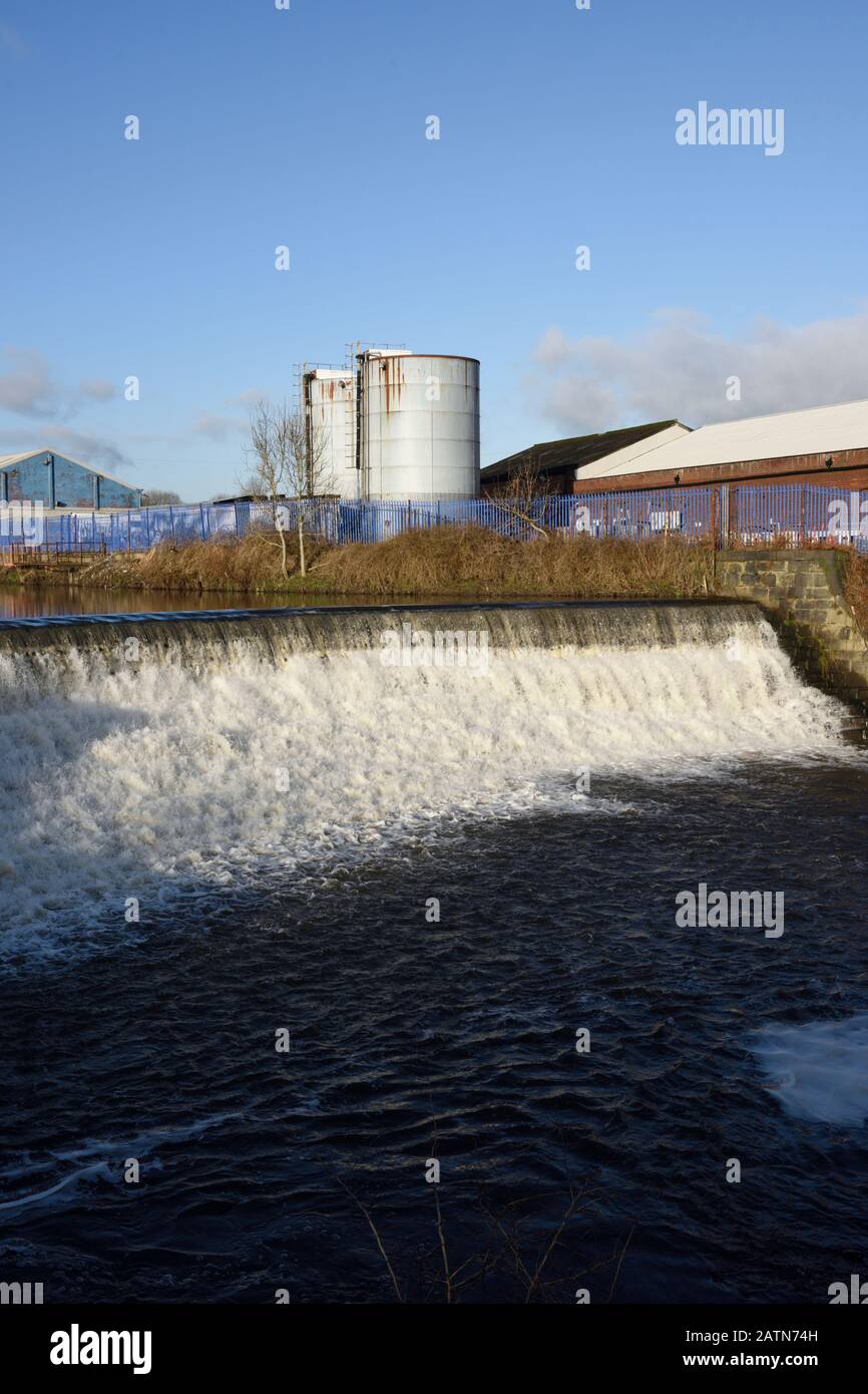 Wehr an der irwell mit Industriegebäuden und Silos in Der Hintergrund in radcliffe in Bury lancashire uk Stockfoto