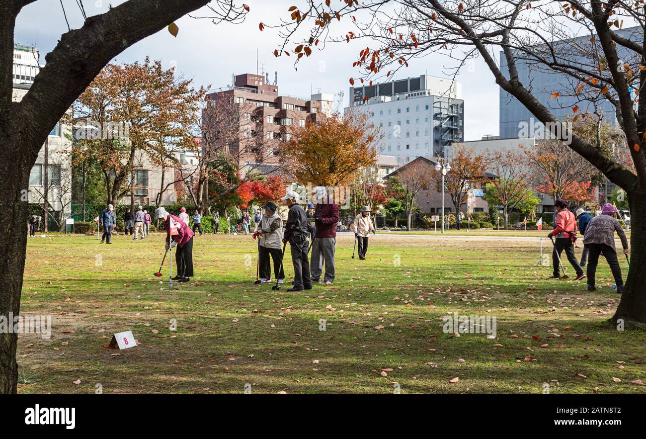 Ältere Leute spielen auf einem grünen Platz in Kanazawa einen Toreball Stockfoto