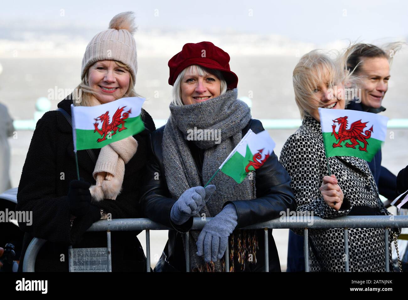 Mitglieder der Öffentlichkeit halten walisische Flaggen fest, während sie auf die Ankunft des Dukes und der Duchess of Cambridge warten, wo sie die RNLI Mumbles Lifeboat Station, in der Nähe von Swansea in Südwales besuchen werden. Stockfoto